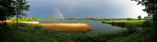 Der Ilkerbruchsee bei Wolfsburg bei abziehendem Schlechtwetter mit Regenbogen und Nebenregenbogen, Blick aus dem NABU-Beobachtungsstand. Panoramaaufnahme, montiert aus vier Einzelaufnahmen.

Aufnameort: Ilkerbruch bei Wolfsburg
Kamera: Canon Powershot Pro1