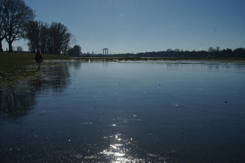 Nur scheinbar steht der Betrachter mitten im Rhein, in Wirklichkeit hat sich die Fläche auf den Poller Wiesen im Februar 2021 in eine spiegelglatte Eisfläche verwandelt. Im Hintergrund ist die Rodenkirchener Brücke zu erkennen.

Aufnameort: Poller Wiesen Köln
Kamera: Sony Alpha 7/II