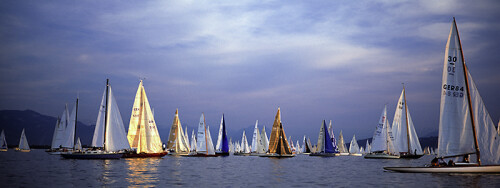 Kurz vor dem Start: Jedes Jahr findet am Bodensee die Rund Um Langstreckenregatta statt. Auf einer Startlinie von ca. 2 km 
starten abends ca. 400 – 500 Segelboote und segeln durch die 
Nacht von Lindau nach Überlingen und zurück. Von einem
Motorboot, welches eine Begrenzungsboje der Startlinie setzte
gelang mir dieses Bild mit einem Segelboot im „natürlichen 
Spotlicht“.

Aufnameort: Lindau, Bodensee, Bayern
Kamera: Hasselblad X-Pan II (f4/90mm)