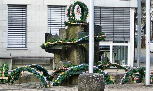 Der Brunnen des Rathauses Eibelshausen österlich dekoriert
https://de.wikipedia.org/wiki/Eschenburg#/media/File:Eschenburg_Rathaus.JPG

Aufnameort: Eibelshausen Rathaus
Kamera: Medion Camcorder